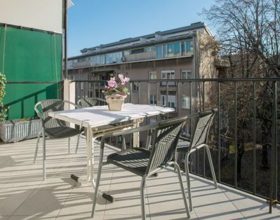 Sunny terrace with flowers and table with 4 chairs.